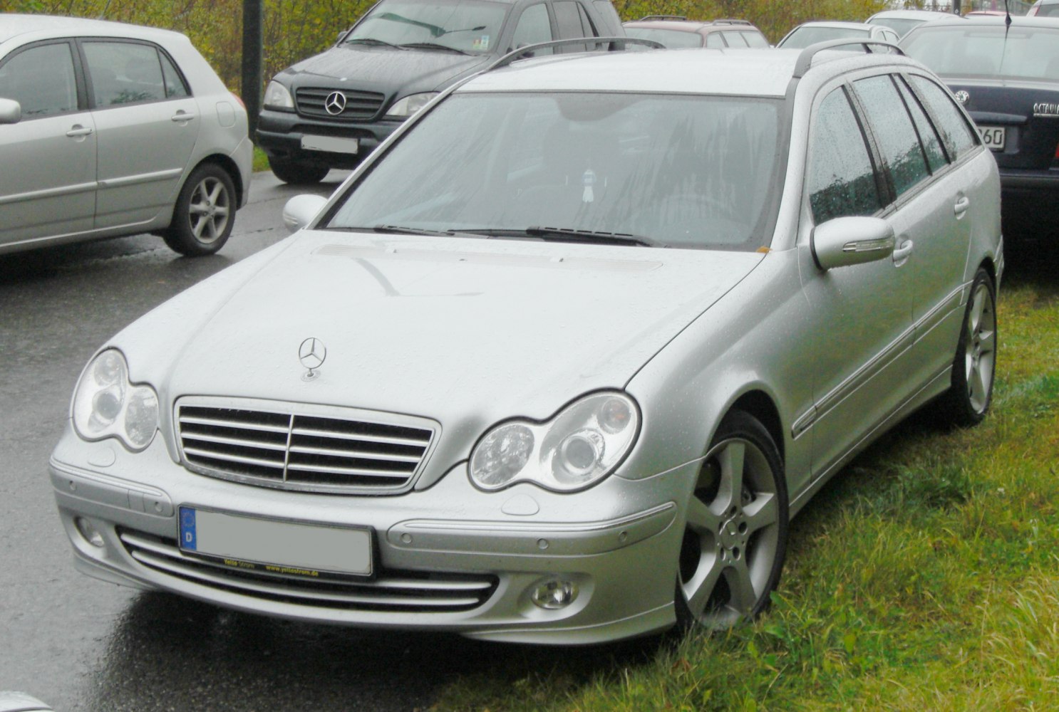 Front and side view of a silver estate with distinctive headlight and grille design