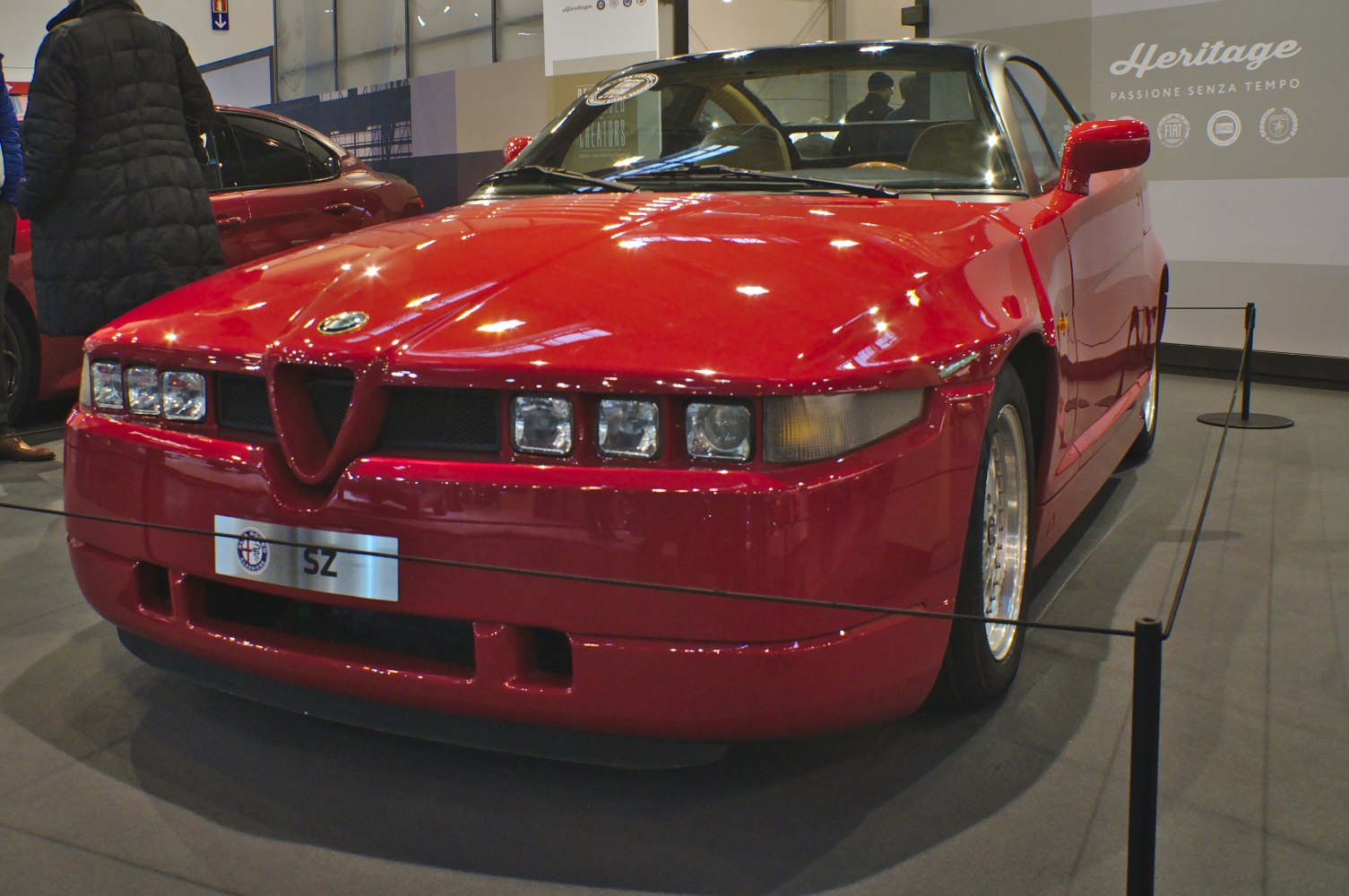 Red sports coupe with distinctive quad square headlights and unique front grille