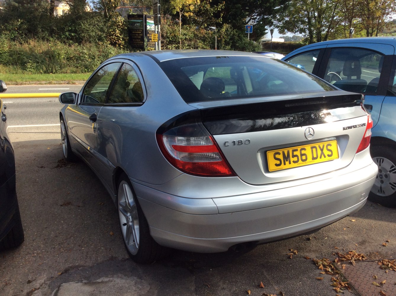 Rear view of a silver luxury coupe with distinct taillights and rear spoiler.
