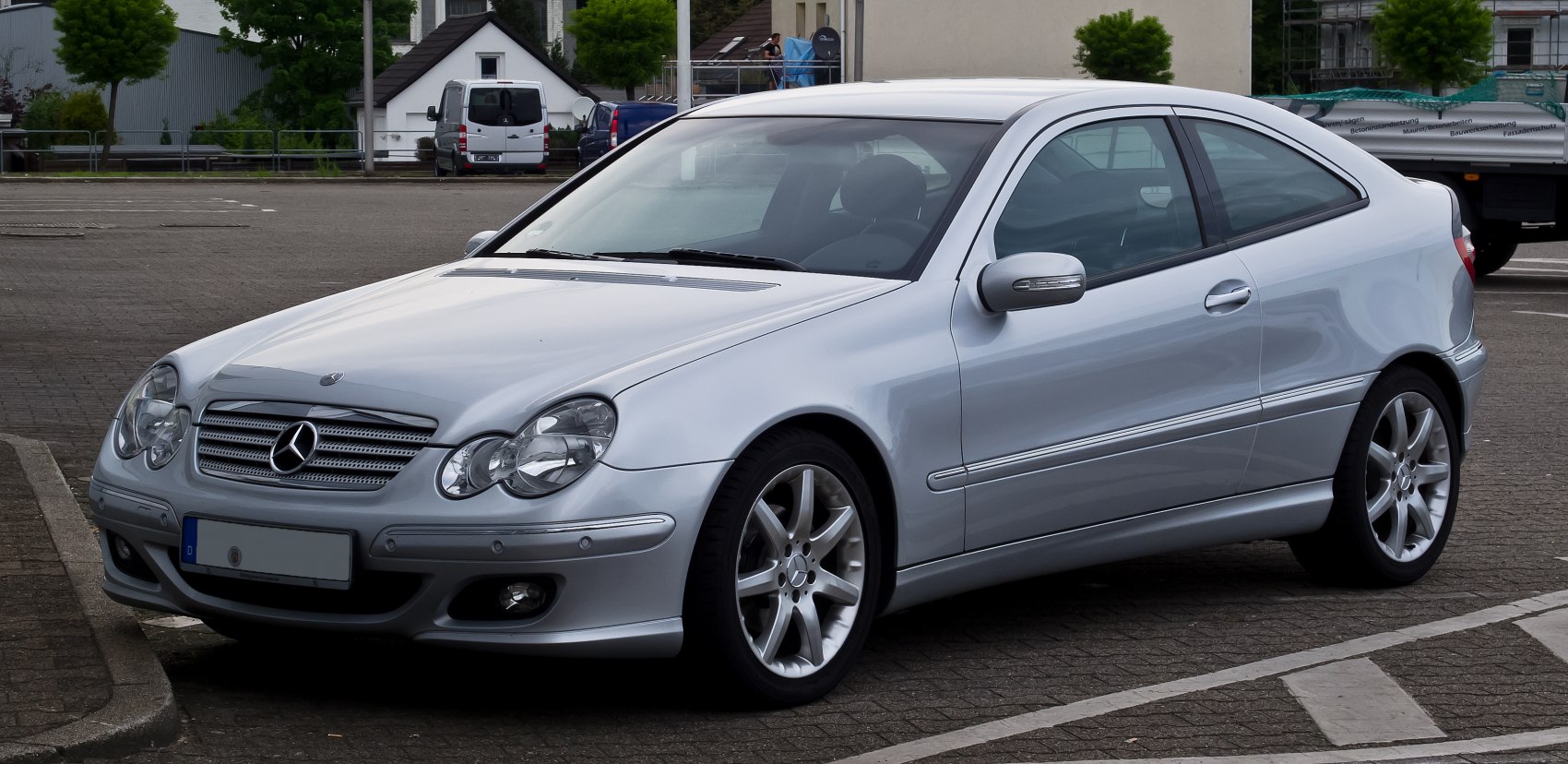 Silver coupe showing front grille, headlights, and side profile with alloy wheels