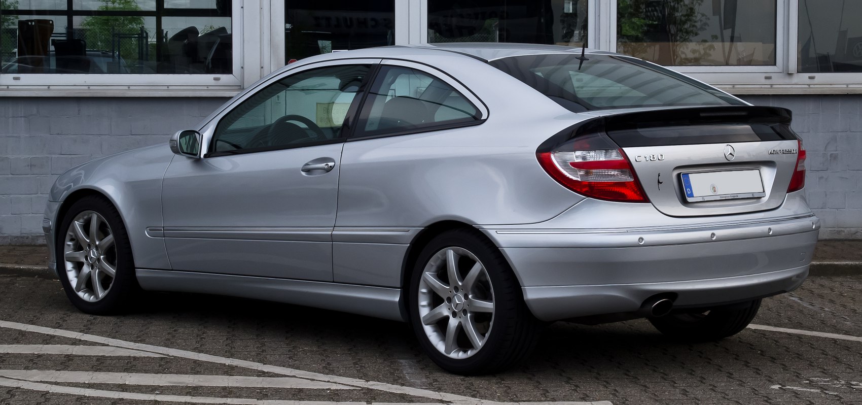 Silver coupe with sleek rear-side profile and alloy wheels