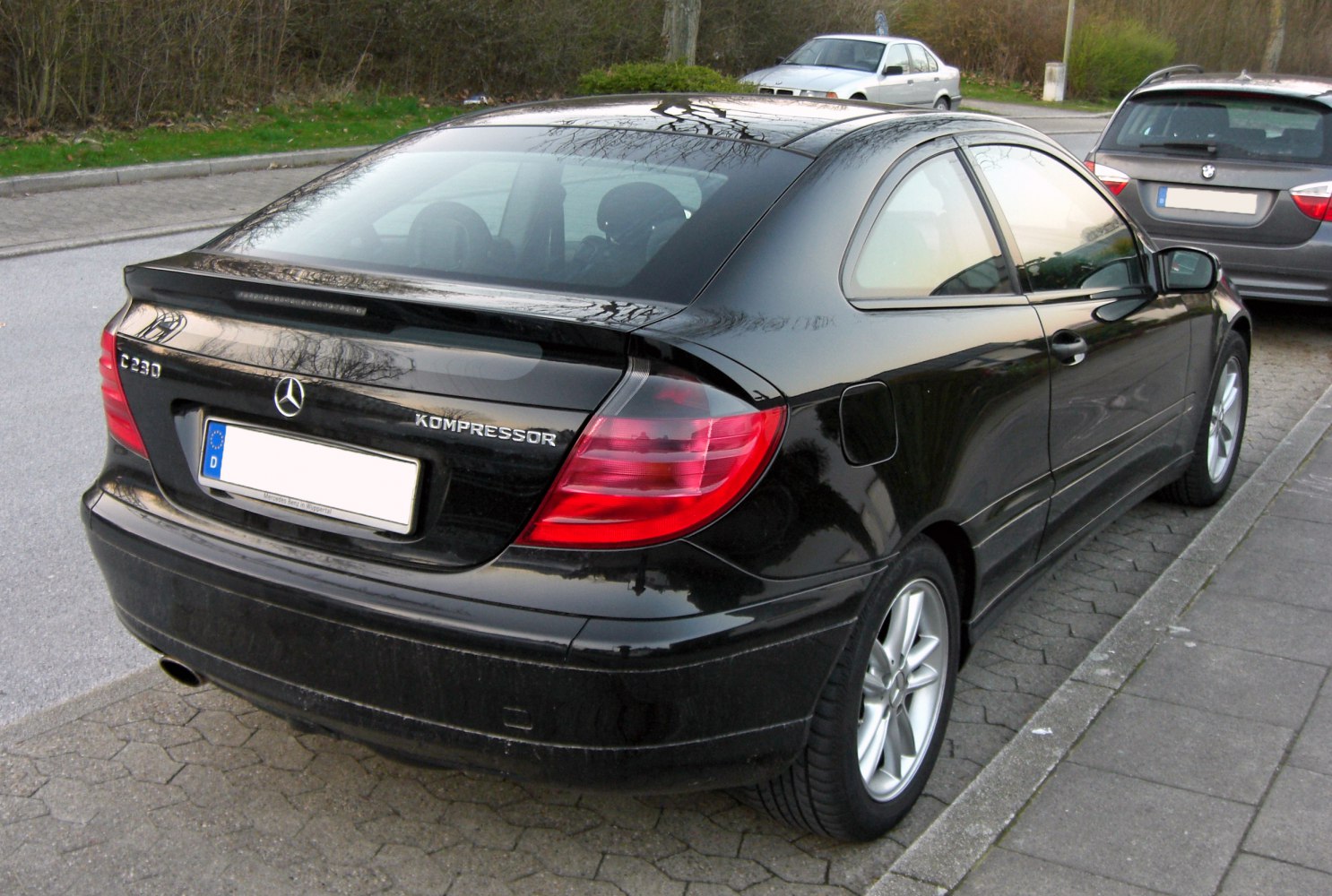 Rear view with spoiler, taillights, fuel cap, and alloy wheels