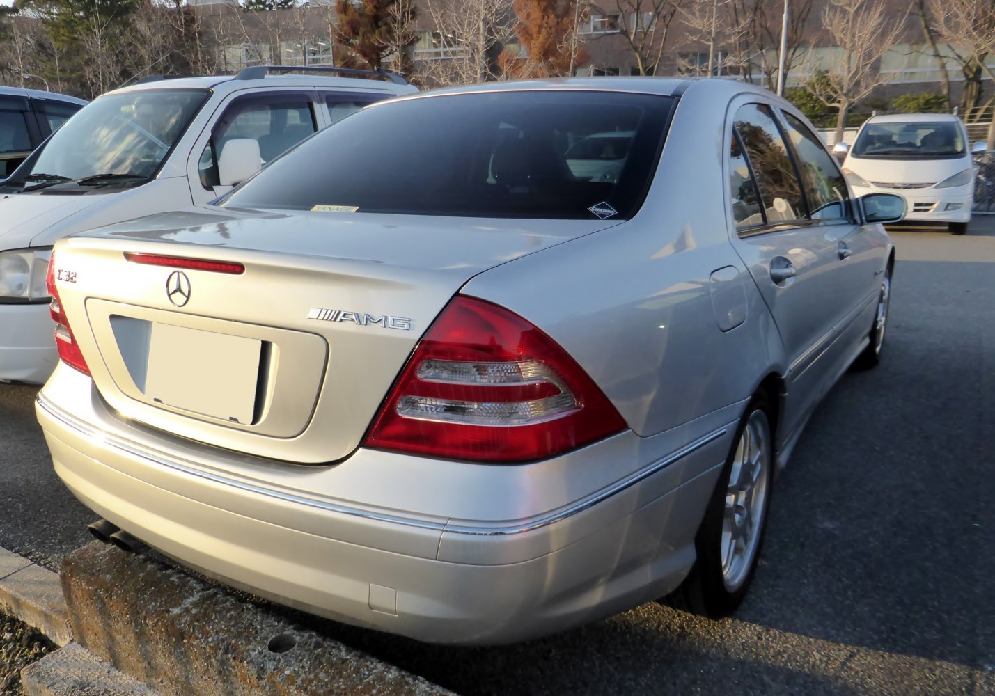 Rear view of a silver sedan with AMG badge and distinct taillights