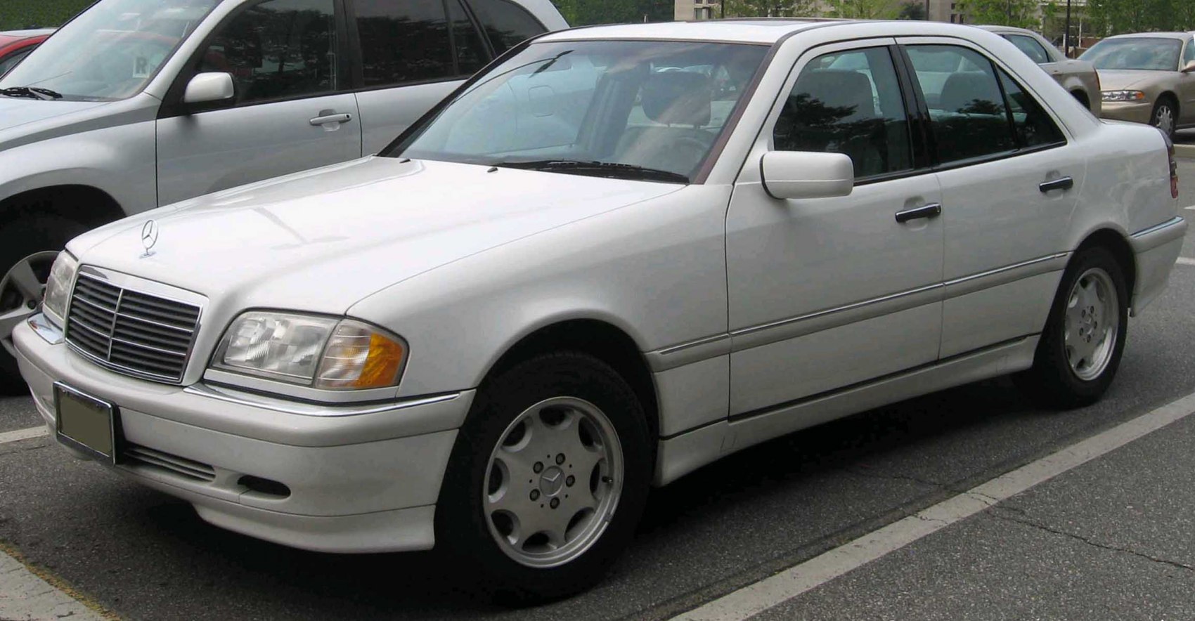 Front-side view of white mid-90s sedan with alloy wheels