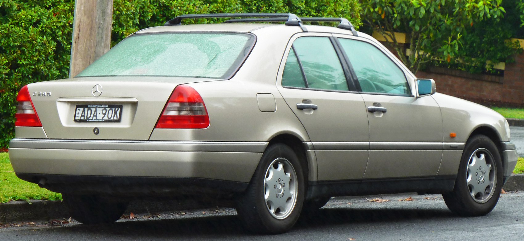 Rear and side profile of a sedan with roof rails
