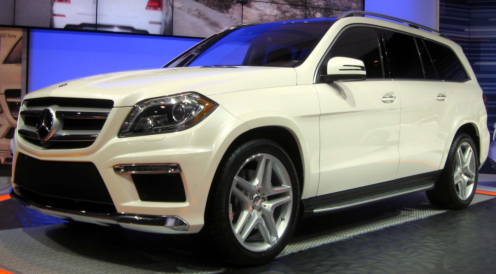 Front and side view of white luxury SUV with distinctive grille and alloy wheels