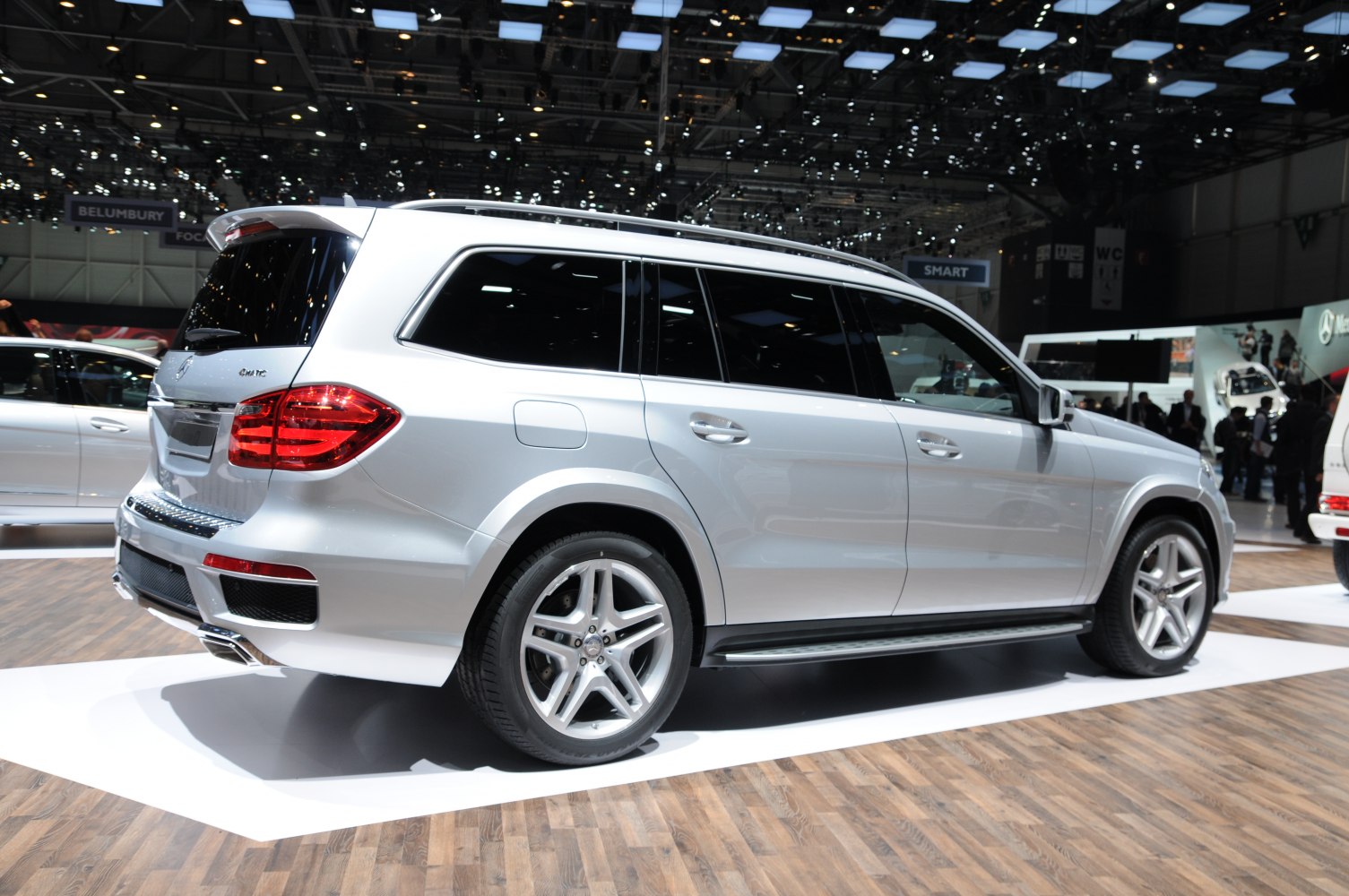 Silver luxury SUV side and rear profile with tinted windows and large wheels.