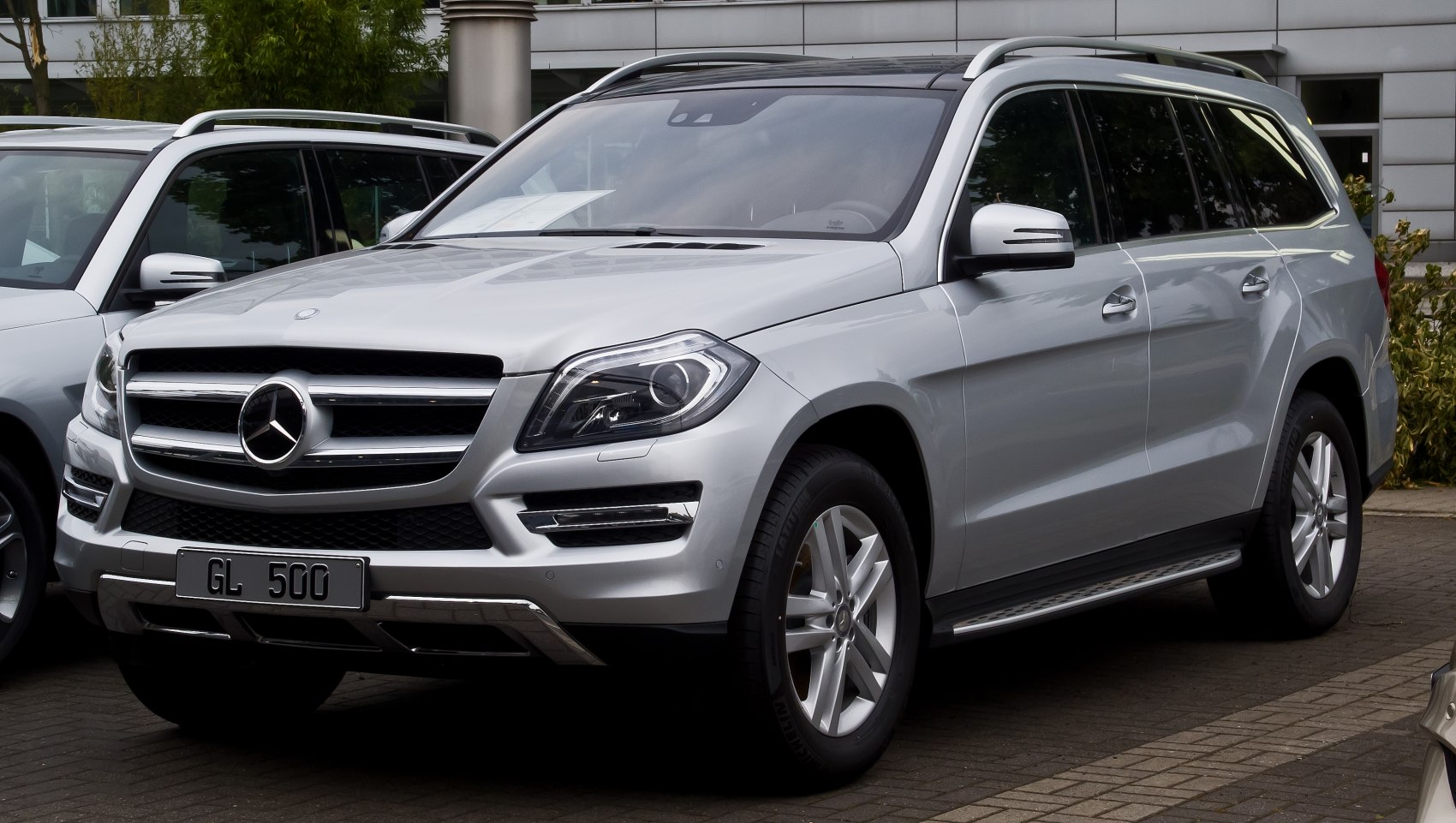 Large silver SUV front-side with LED headlights and roof rails
