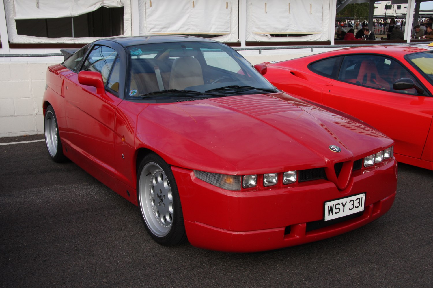 Red sports coupe with angular headlights and wide wheels