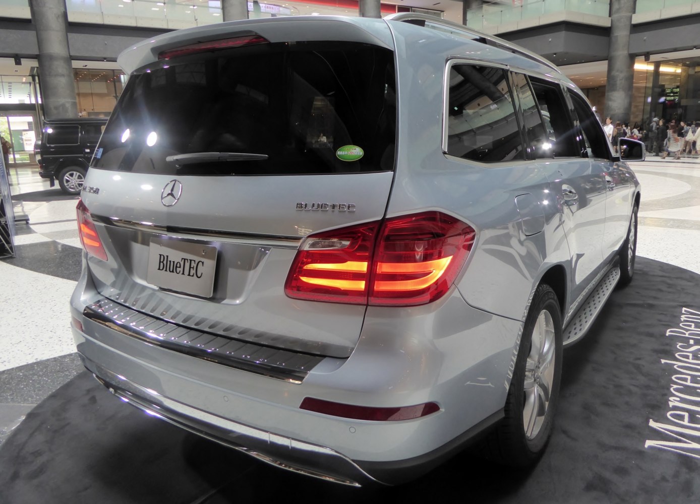 Rear view of a luxury SUV with illuminated taillights and BlueTEC emblem