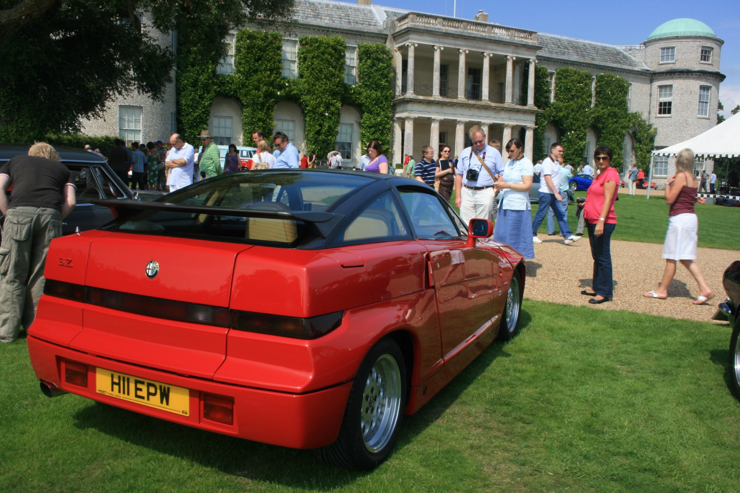 Red coupe with rear spoiler and wide alloy wheels