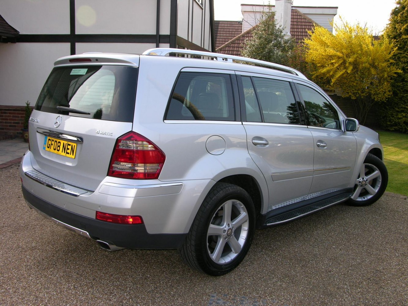 Silver SUV with 4MATIC, roof rails, and alloy wheels rear side view