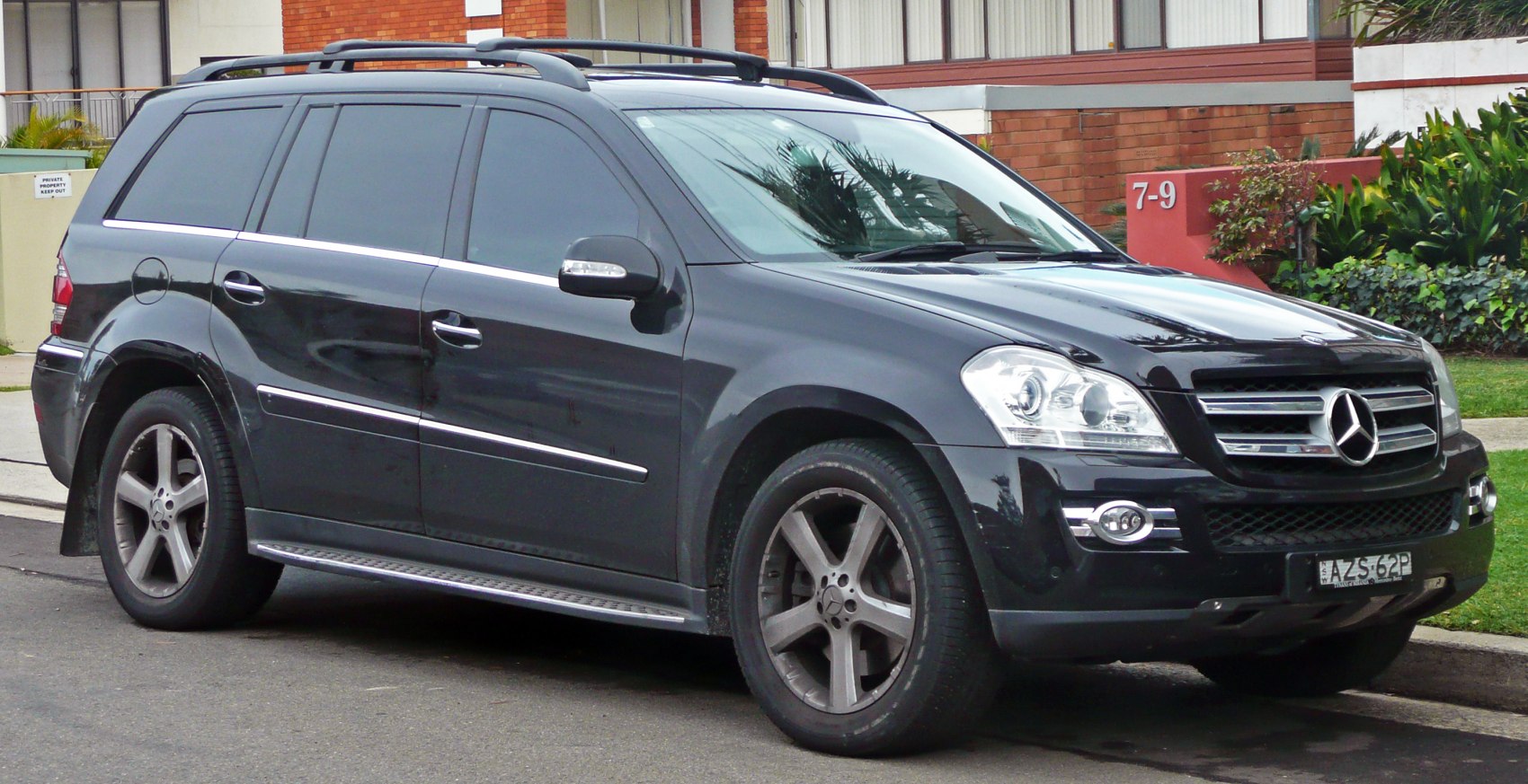 Front side view of a black luxury SUV with roof rails and alloy wheels