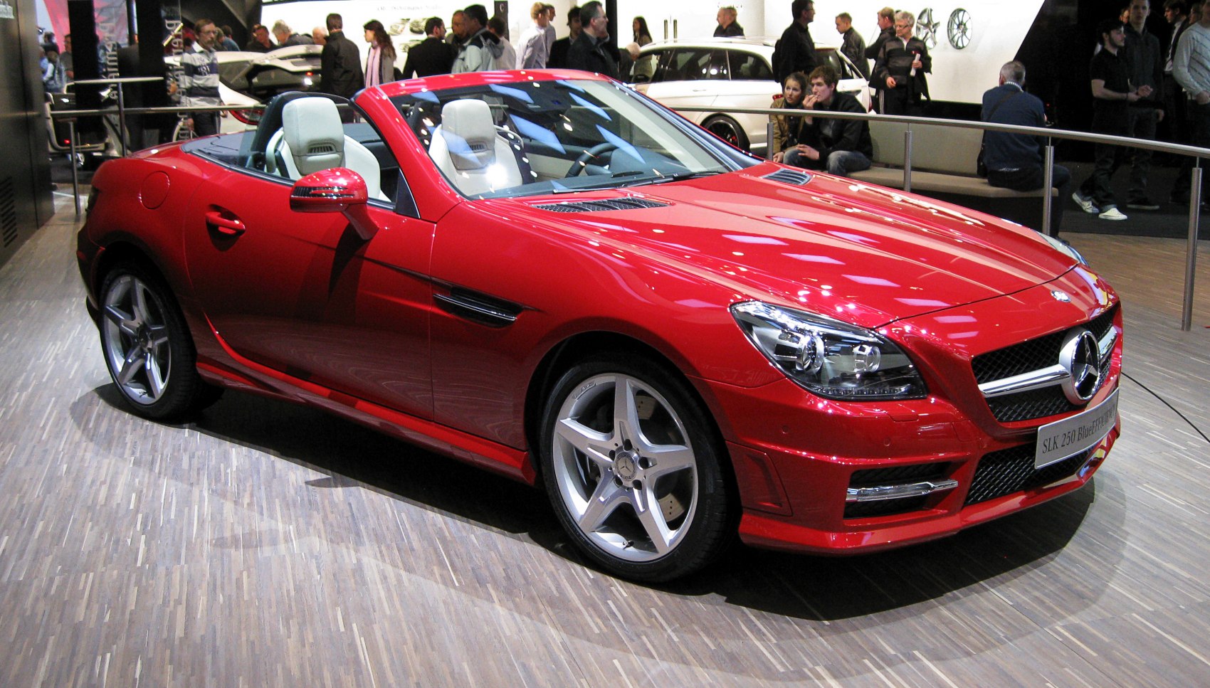 Red convertible with sporty design, alloy wheels, and prominent front headlamps.