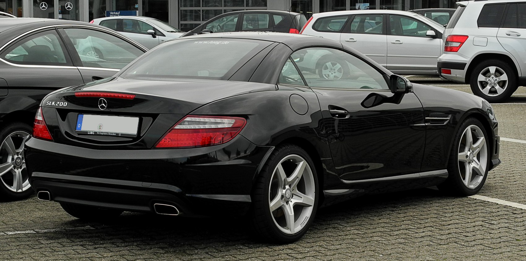 Rear and side view of a black two-door sports coupe with distinct taillights and alloy wheels.
