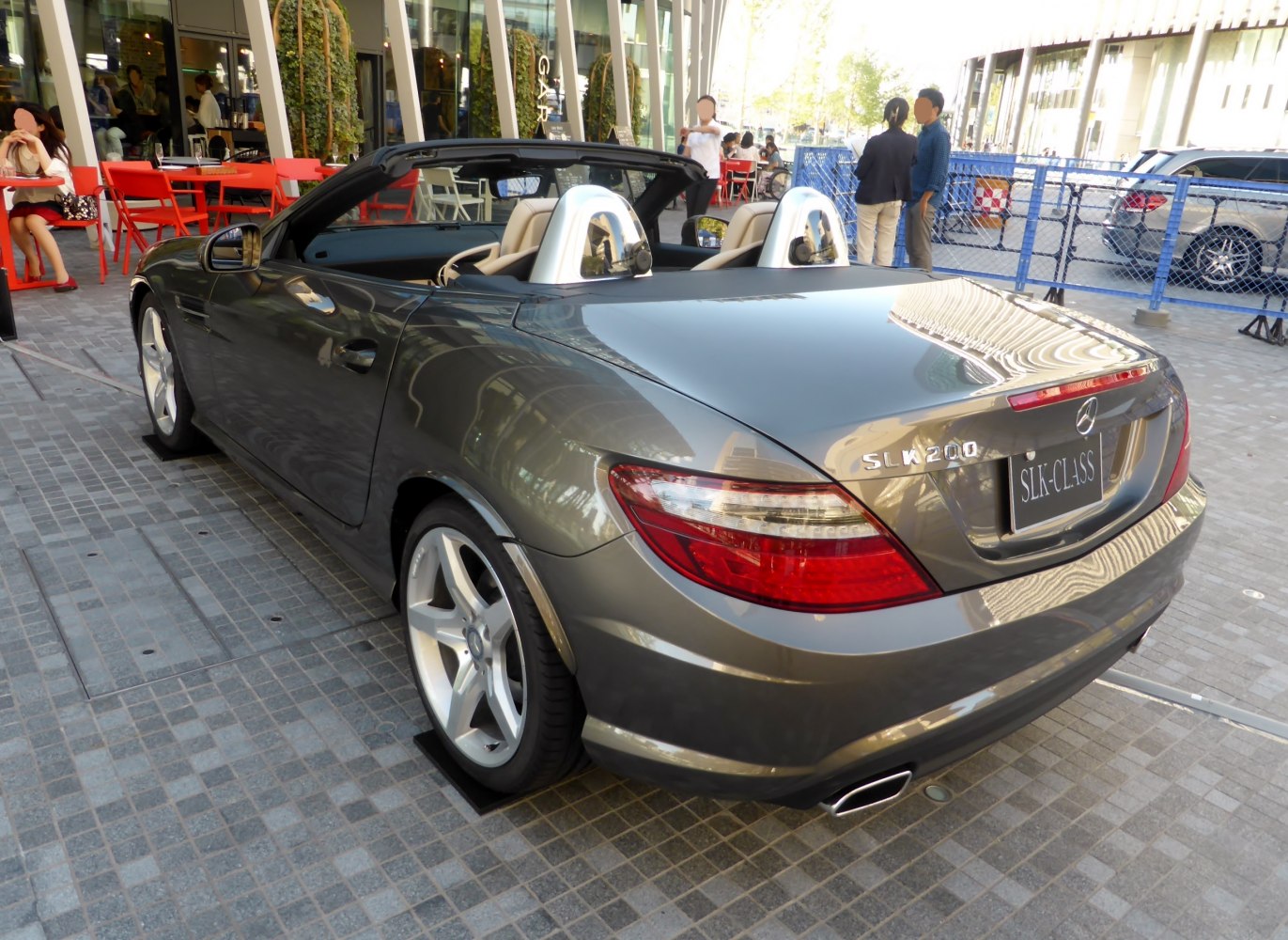 Rear side view of a silver convertible with roll bars