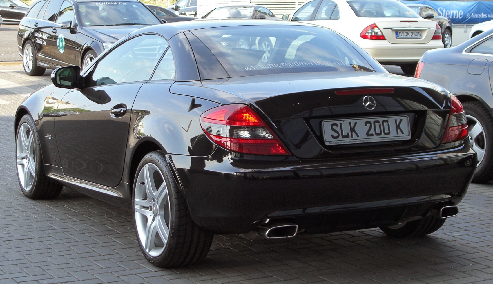 Rear view with dual exhaust and tail lights on a black convertible coupe