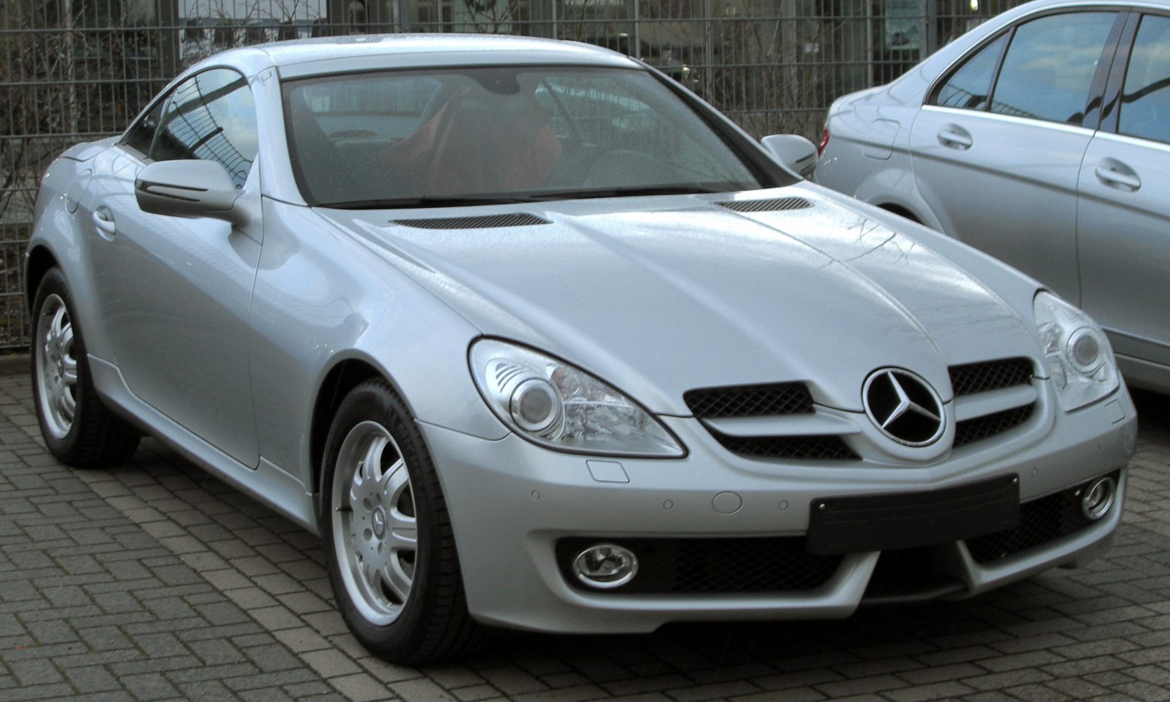 Silver compact sports coupe with hood vents and front fog lights