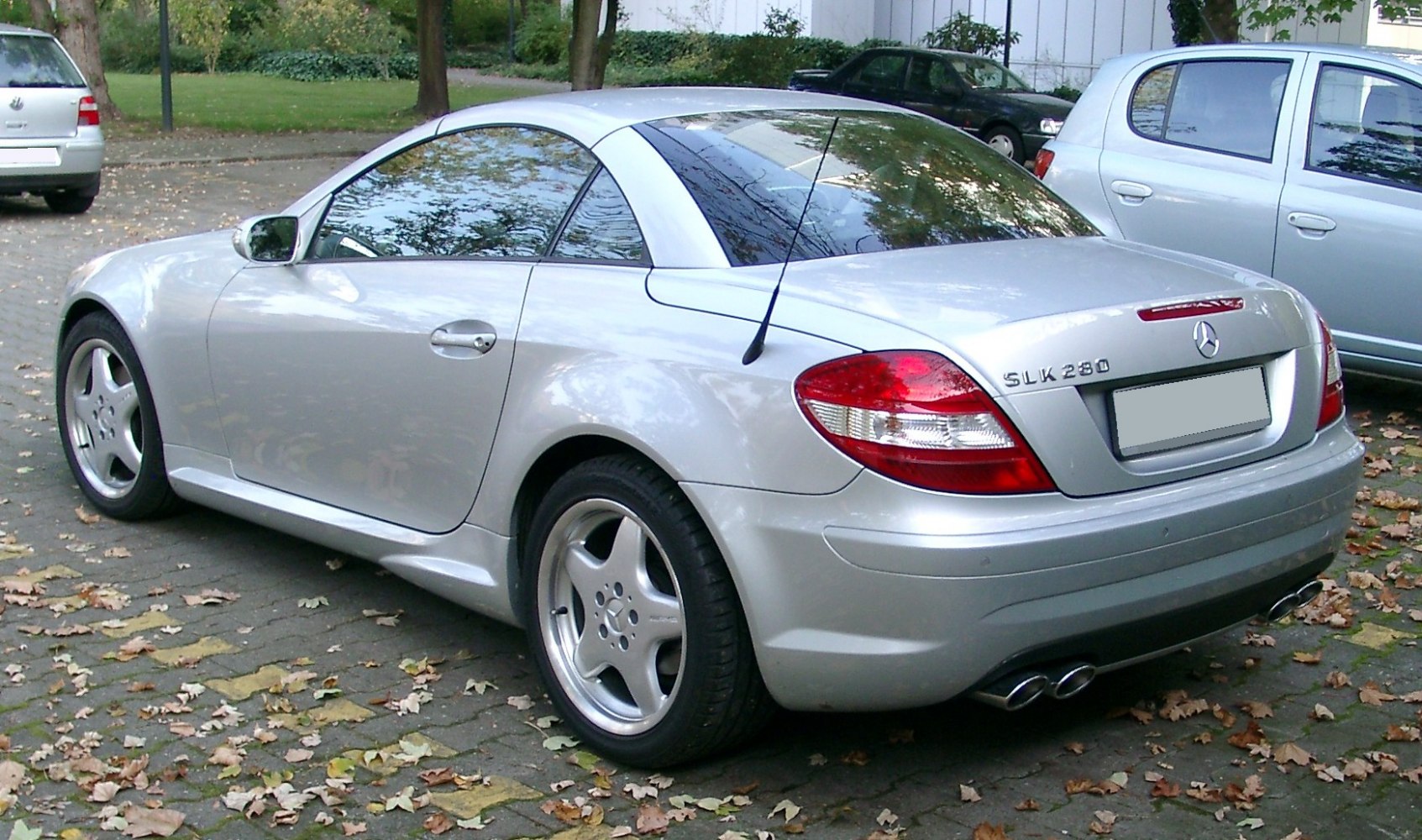 Silver two-door coupe rear and side view with dual exhaust and antenna