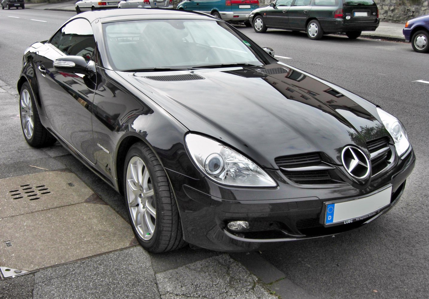 Front view of a black sports roadster with distinctive headlights and grille