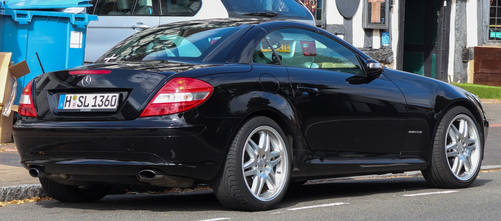 Rear-side view of luxury coupe with AMG wheels and dual exhausts