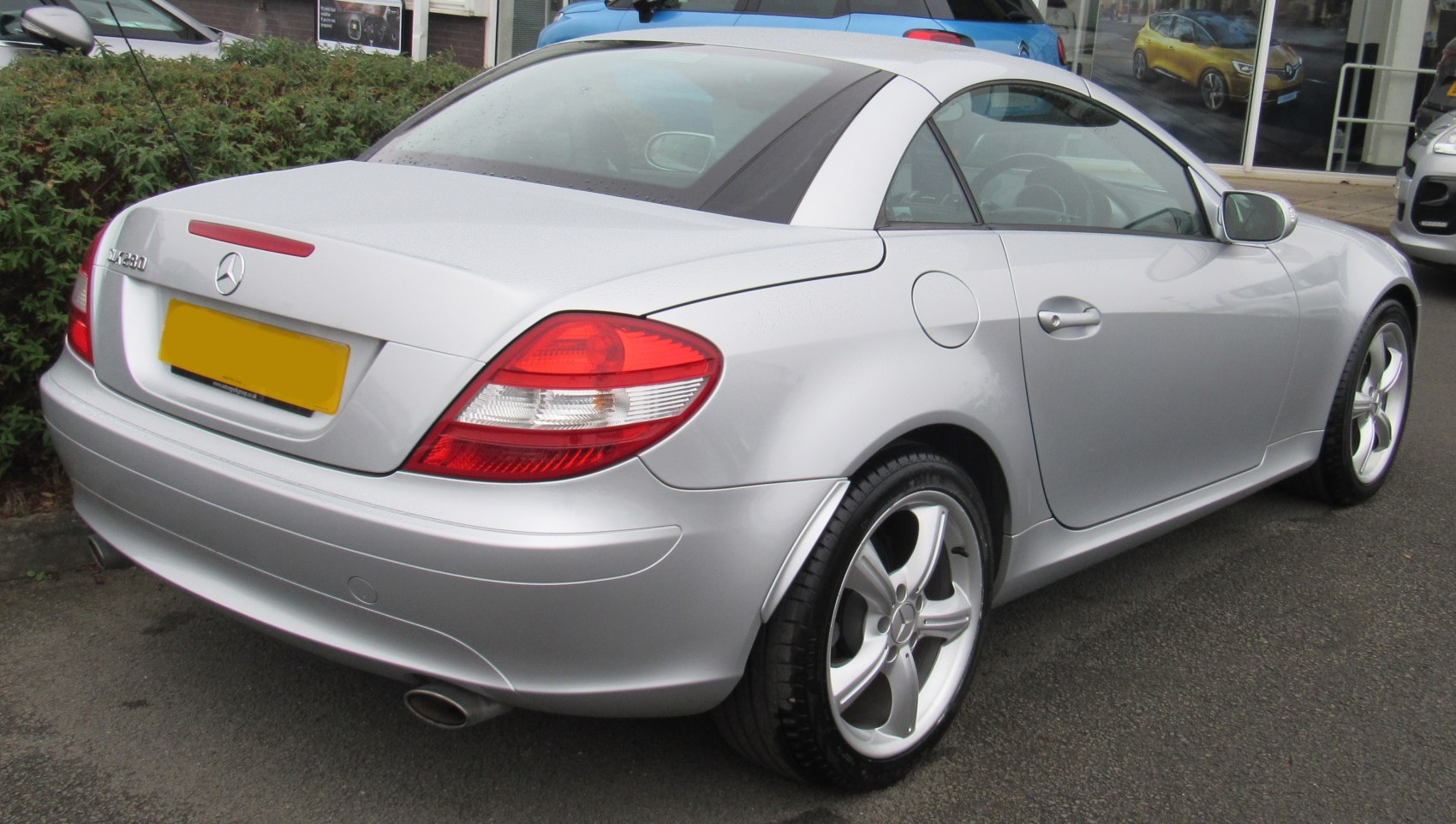 Rear and side view of silver convertible with alloy wheels and distinct taillights
