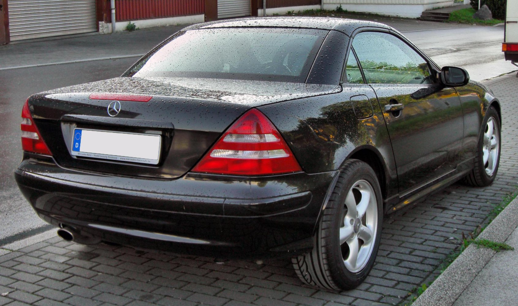 Rear and side view of coupe with taillights and alloy wheels