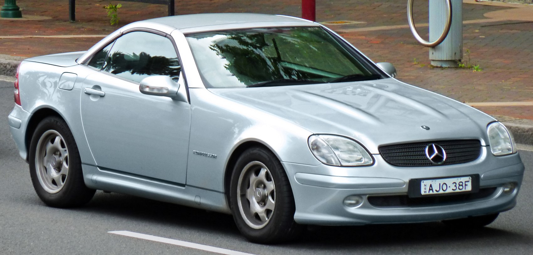 Silver coupe with front and side view, headlamps and alloy wheels.
