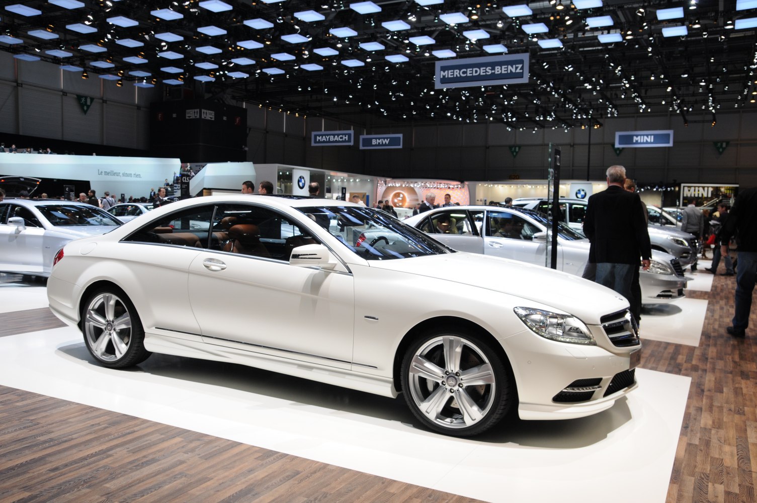 White luxury coupe with sleek design and alloy wheels in auto show setting