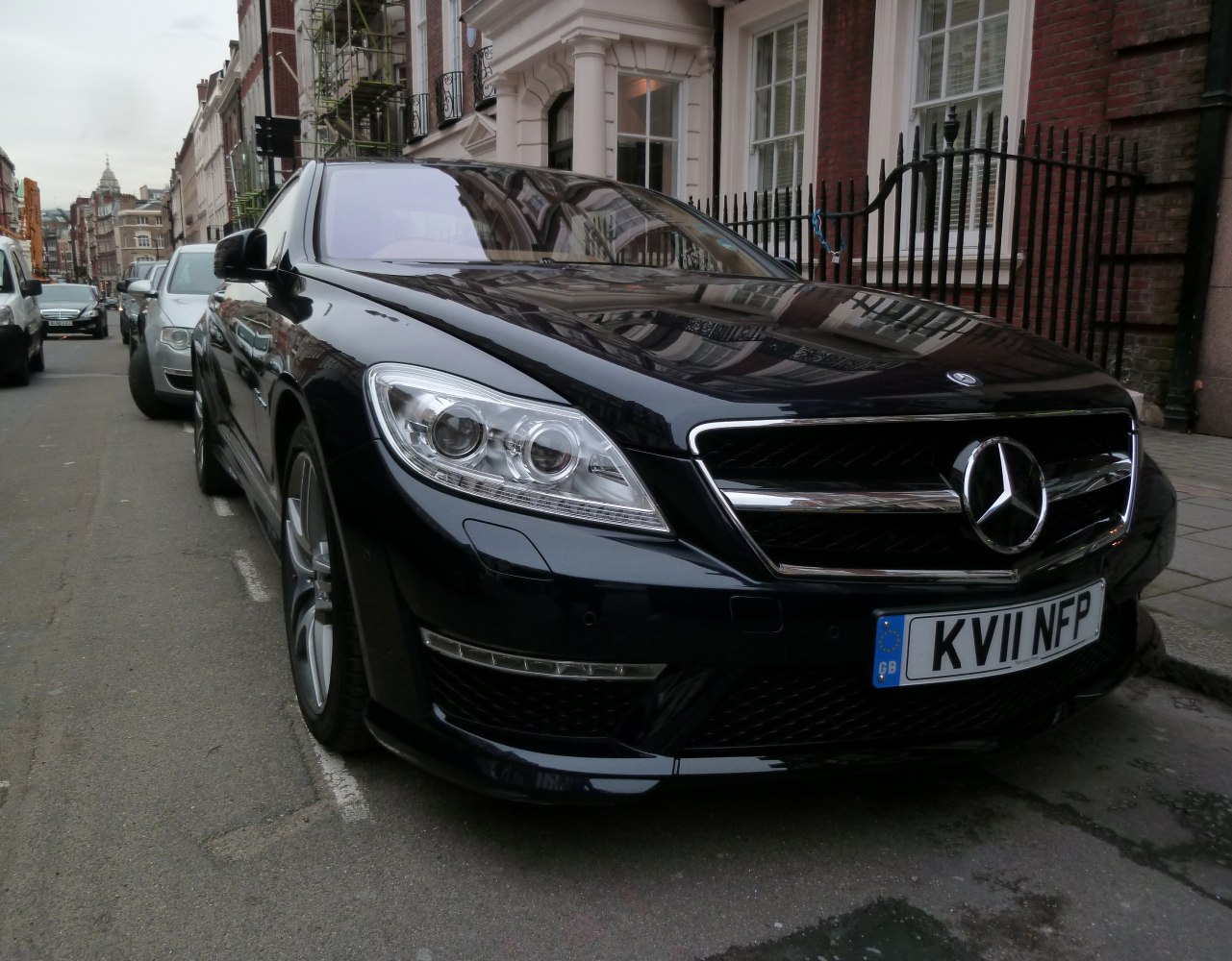 Luxury sedan front with dual round headlights and bold chrome grille