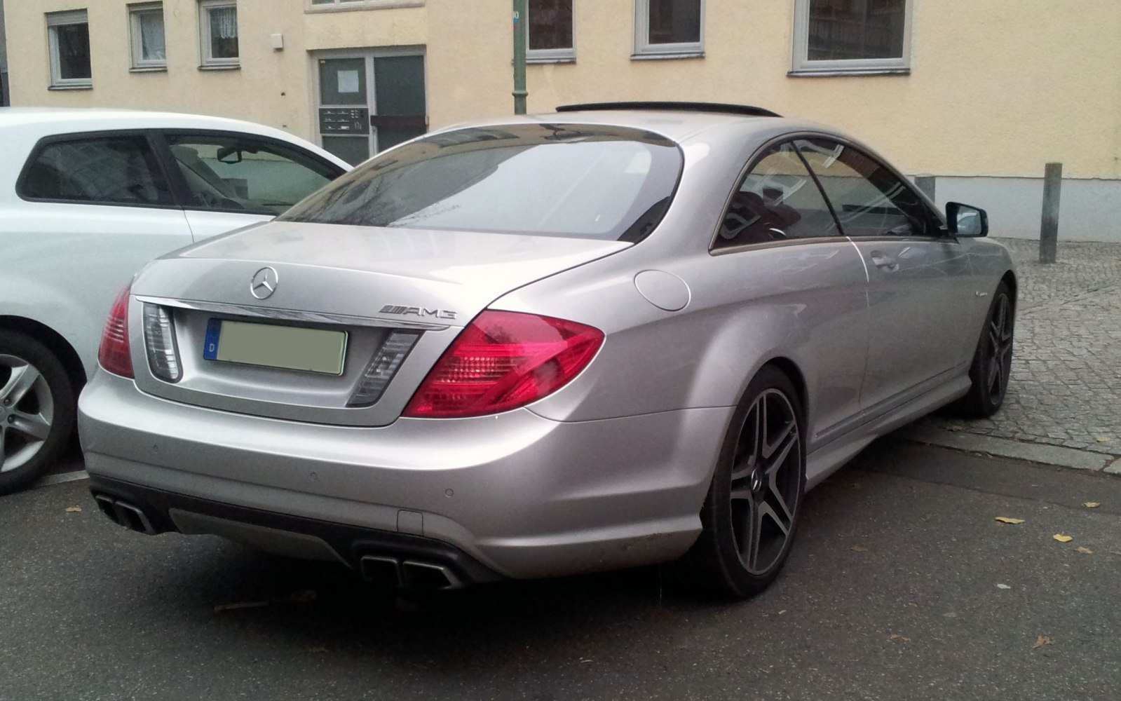 Rear view of a silver coupe with AMG trim and quad exhaust.