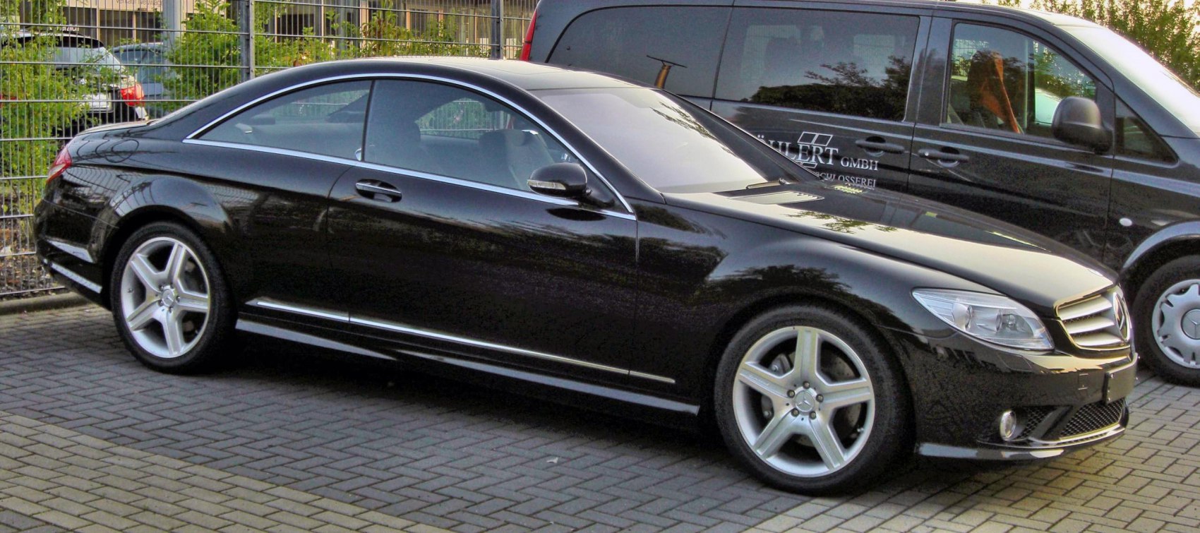 Black two-door luxury coupe with alloy wheels and sleek design.