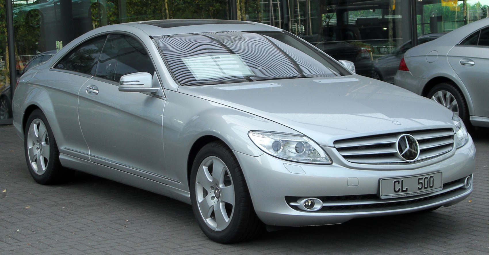 Silver luxury coupe with bold grille and distinct headlights