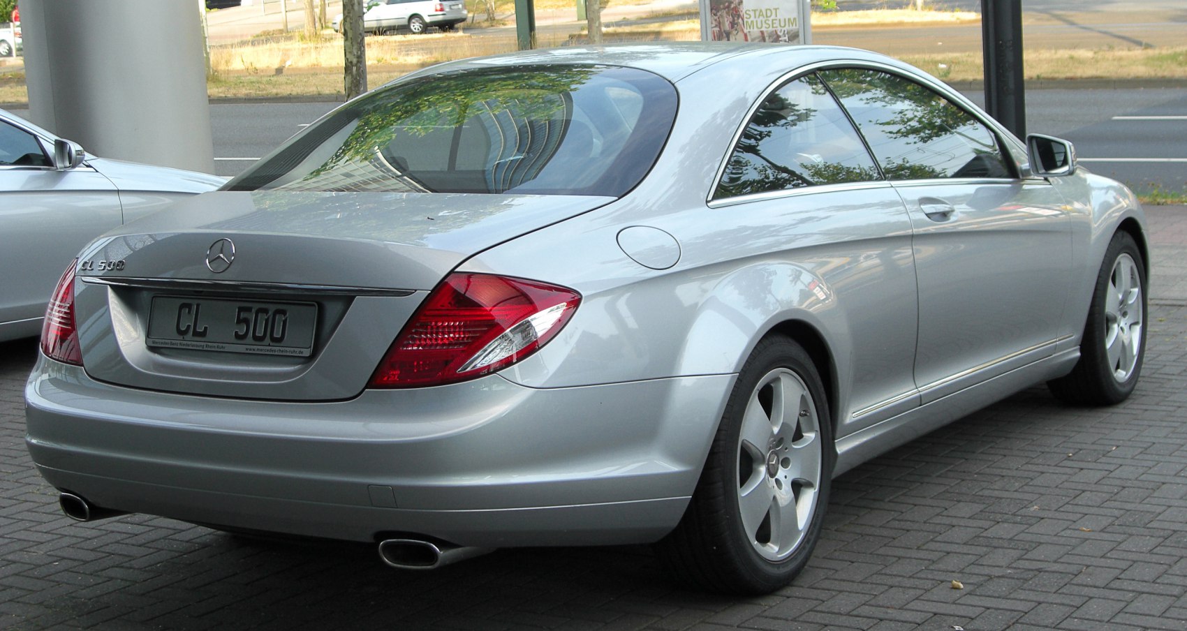 Silver luxury coupe rear and side with dual exhausts and distinctive tail lamps