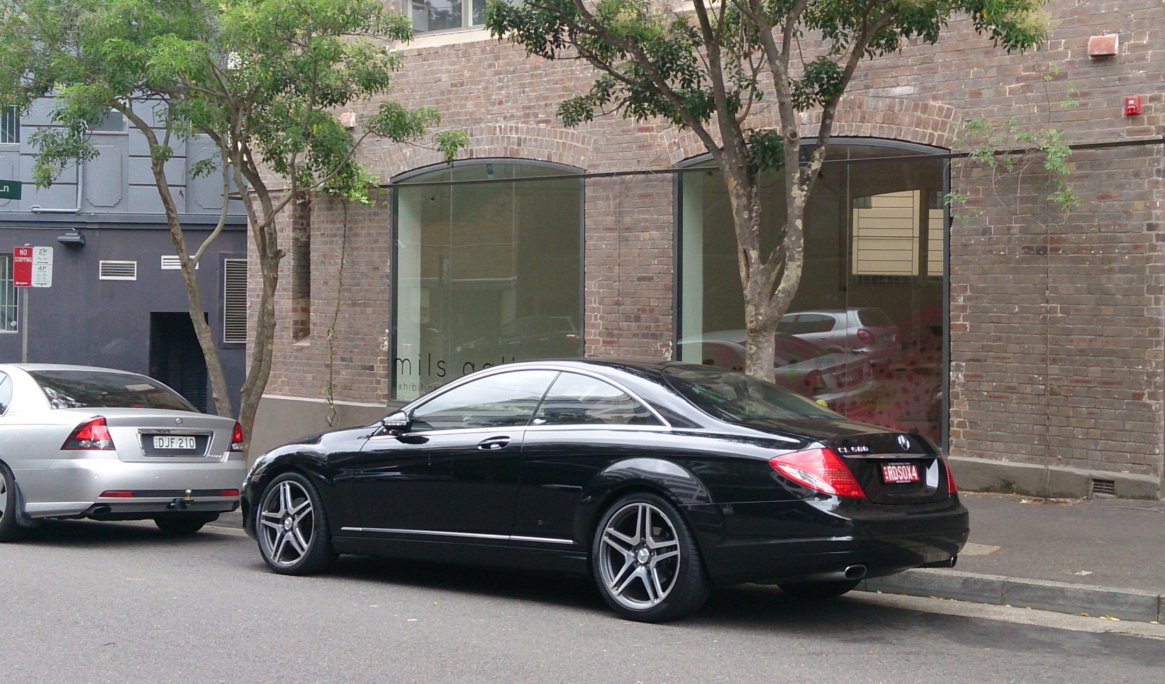 Rear and side profile of a black luxury coupe with stylish alloy wheels.