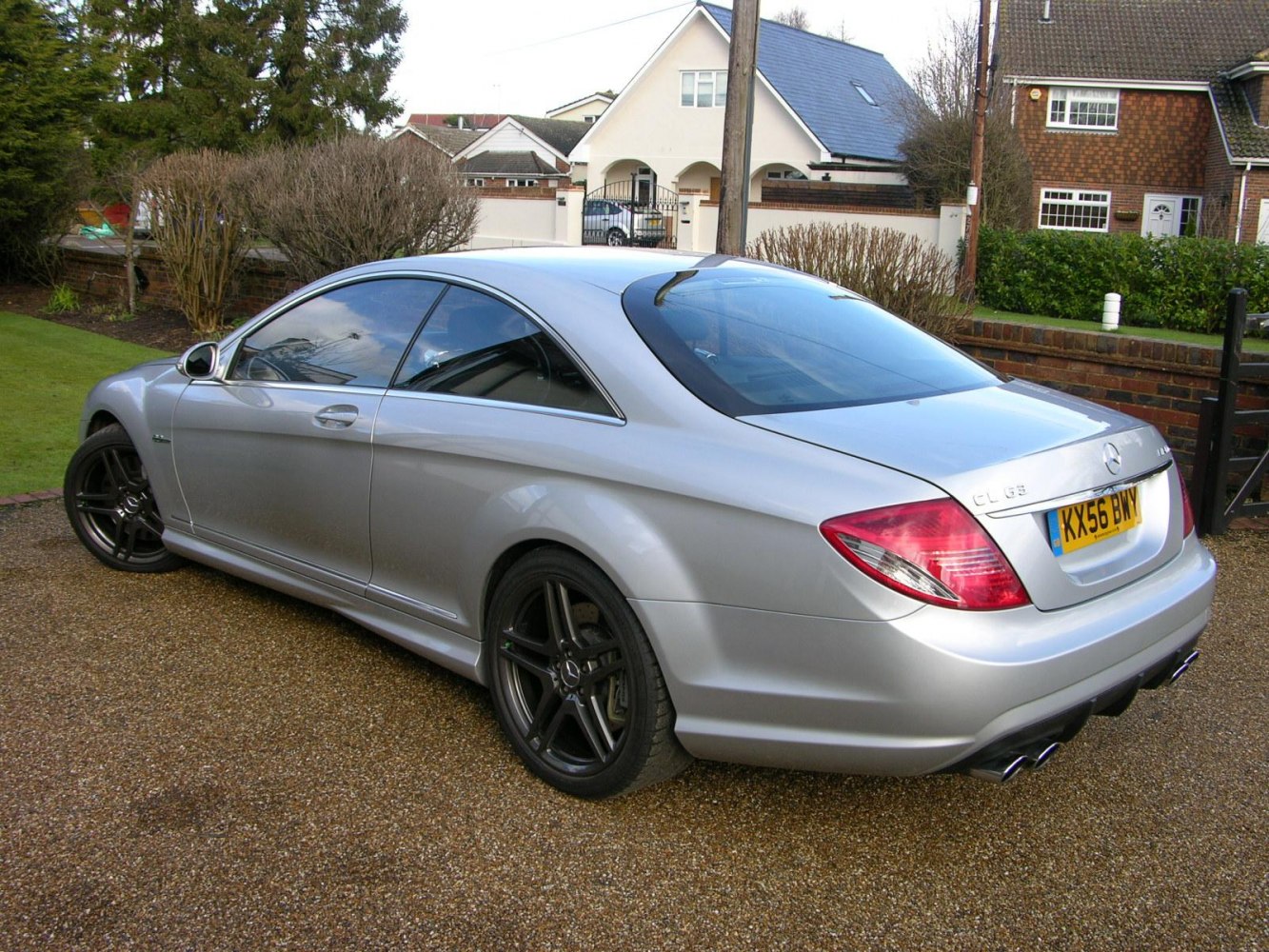 Silver luxury coupe rear side with black sporty wheels and quad exhaust
