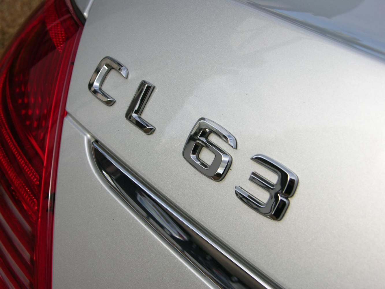 Close-up detail of rear CL 63 chrome emblem and red tail light