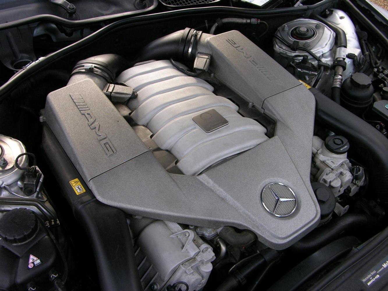 Detailed close-up of AMG engine cover with Mercedes-Benz emblem.