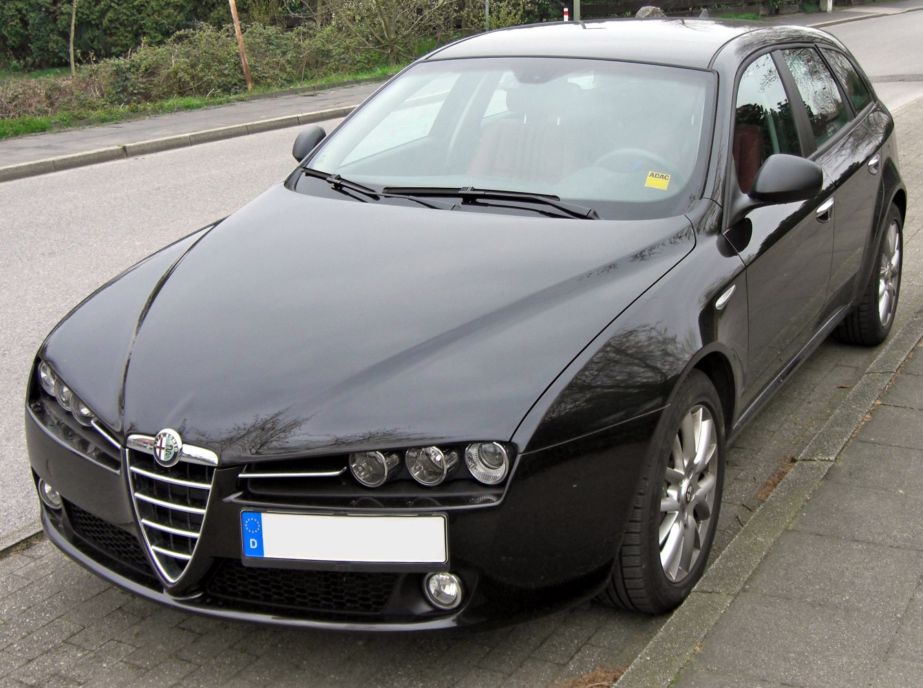 Front view with tri-headlights and chrome signature grille
