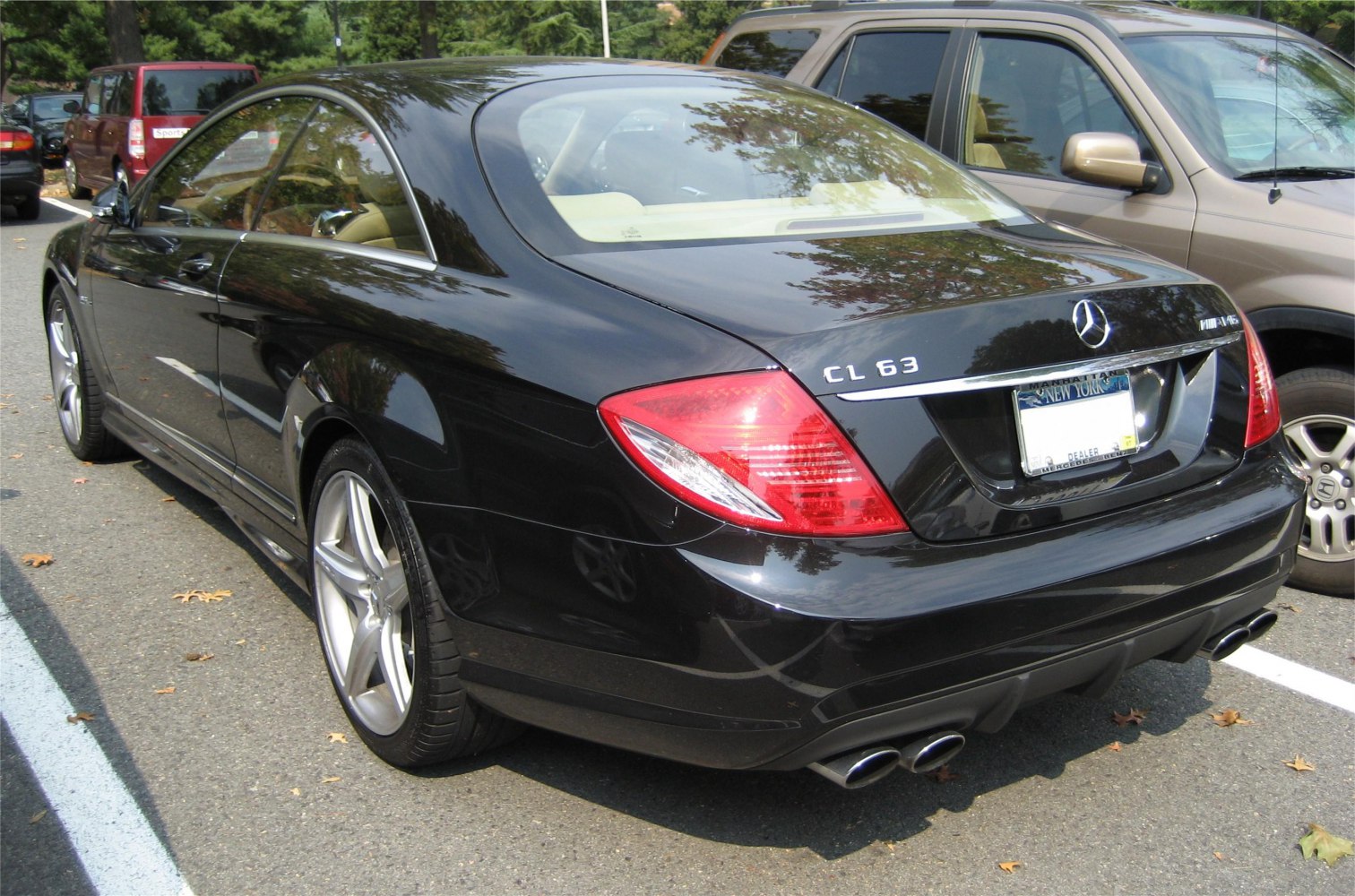 Rear and side profile of a black luxury coupe with quad exhausts and distinctive taillights