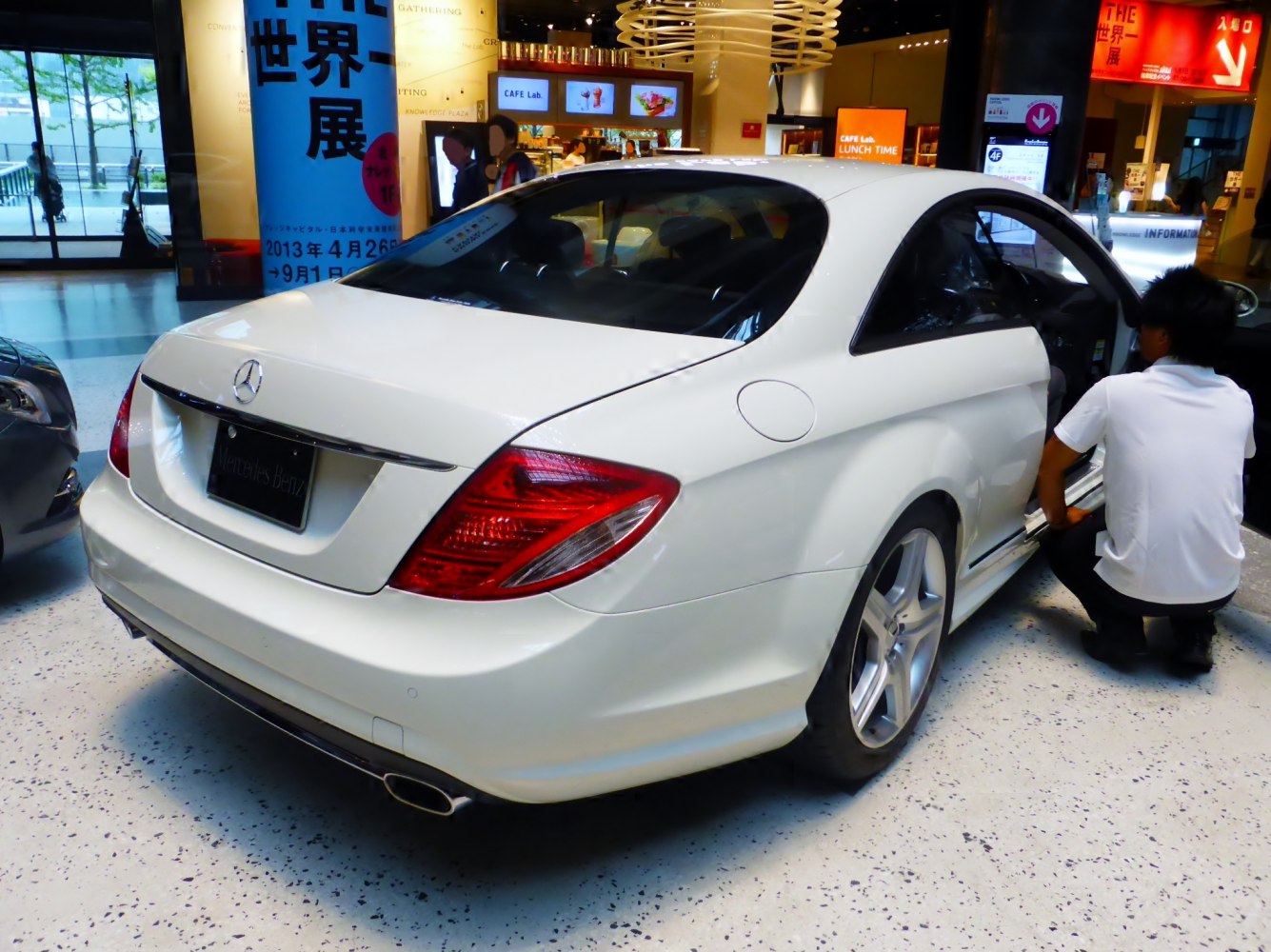 Rear view of white luxury coupe with distinctive taillights and dual exhaust