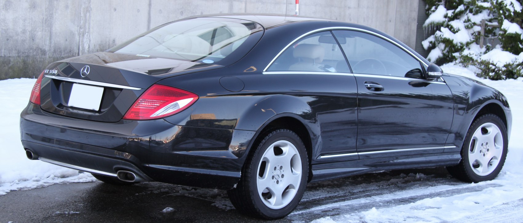 Rear and side view of a luxury coupe with dual exhaust and smooth body lines.