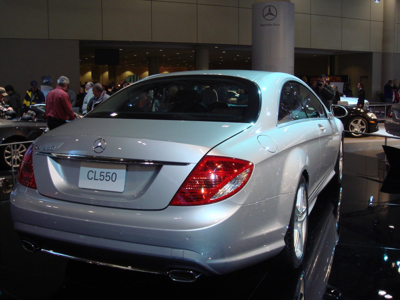 Rear view of silver luxury coupe with tail lights and dual exhaust