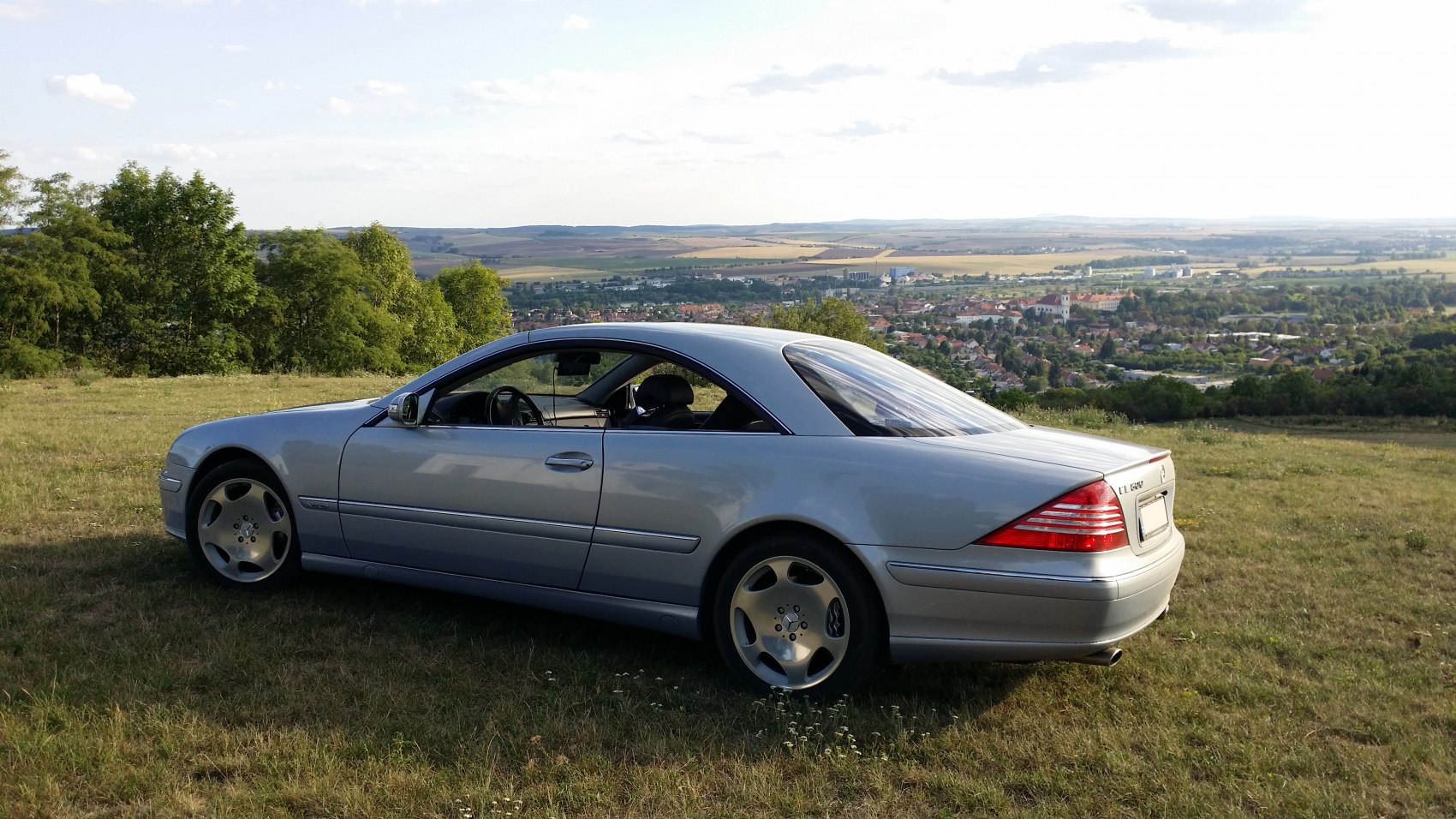 Side profile of sleek luxury coupe with distinctive alloy wheels.