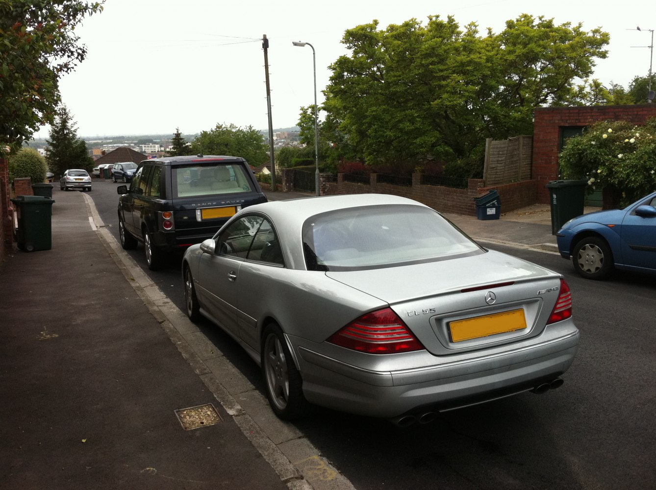 Silver luxury coupe rear with AMG badge and dual exhaust