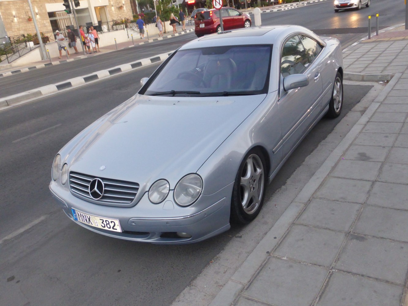 Front three-quarter view of sleek silver coupe with quad round headlights