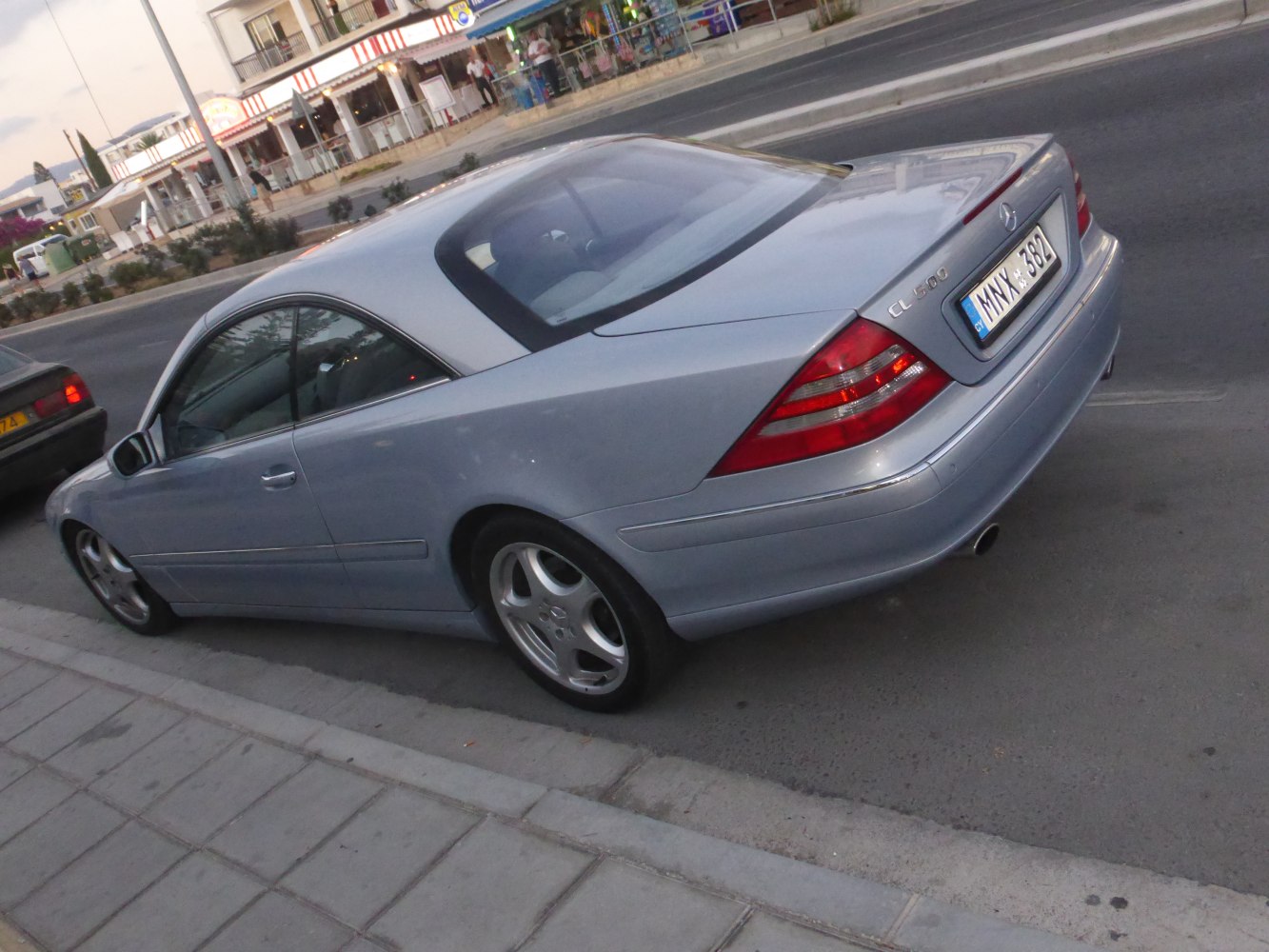 Rear three-quarter view of a luxury coupe with distinctive taillights and alloy wheels