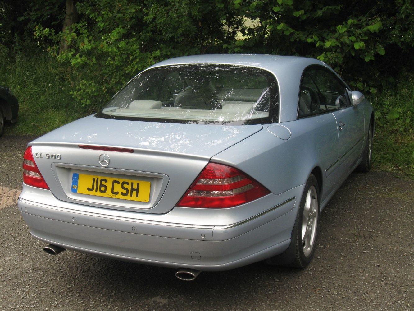 Rear view of a silver luxury coupe with dual exhaust and distinctive taillights