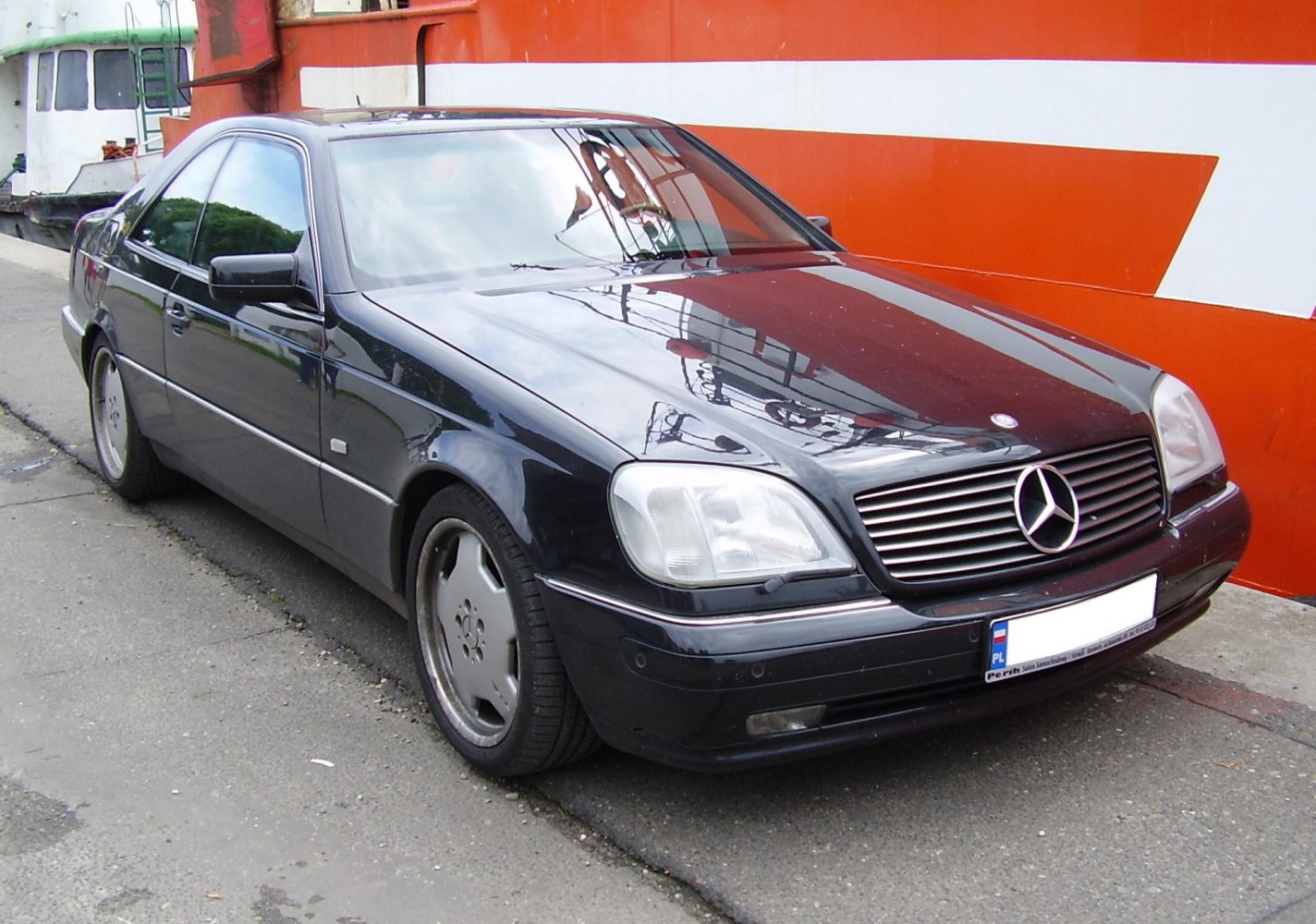 Front and side view of a black luxury coupe with distinctive Mercedes grille.