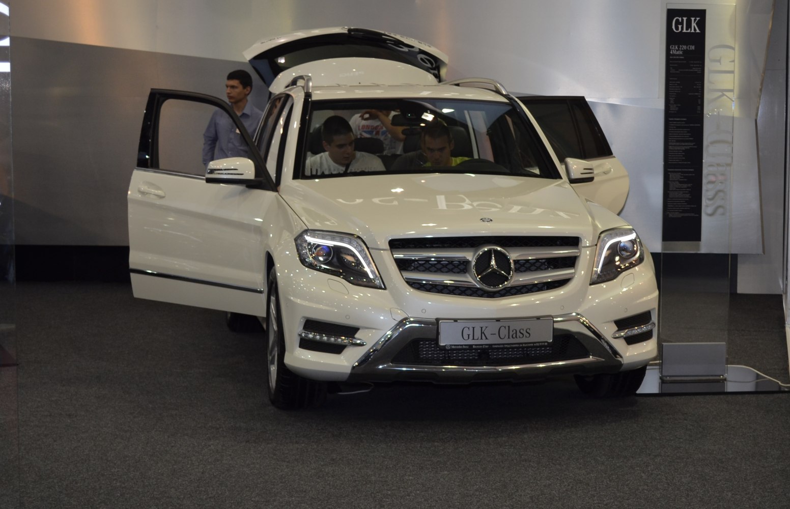 Front view of white SUV with headlights on and open doors